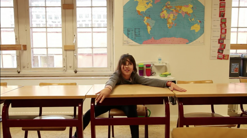 Dansend meisje tussen schoolbanken