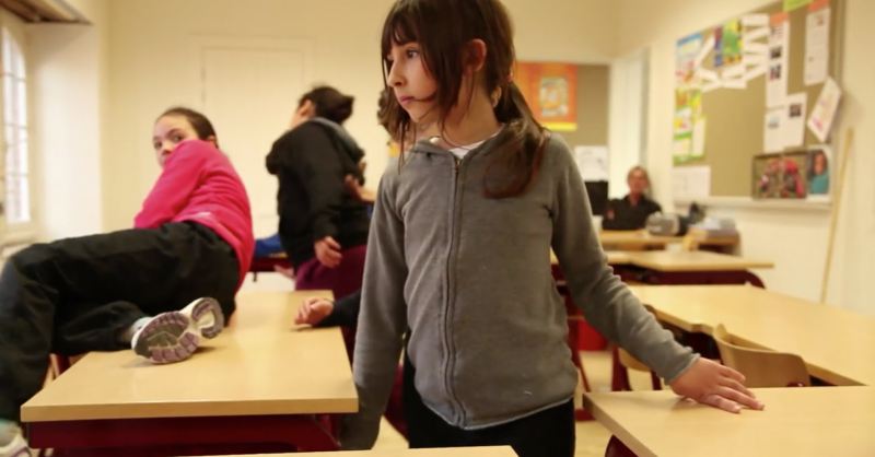 Dansende meisjes tussen schoolbanken