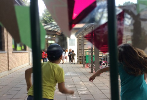 Kinderen rennen op speelplaats in zomerkleren