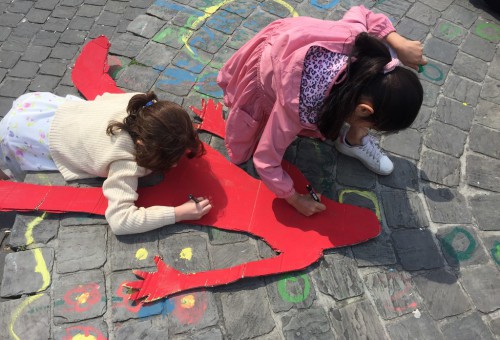 kinderen tekenen op een groot kartonnen figuur