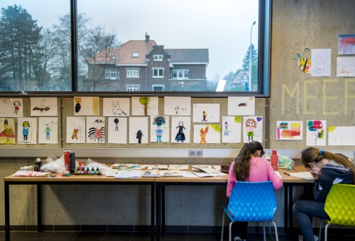 Kinderen tekenen kleurrijke personages aan hun tafel