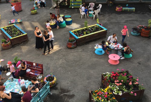 Fête d'école, dehors. Les parents se baladent parmi les installations colorés que Boris a fabriqués avec les enfants.